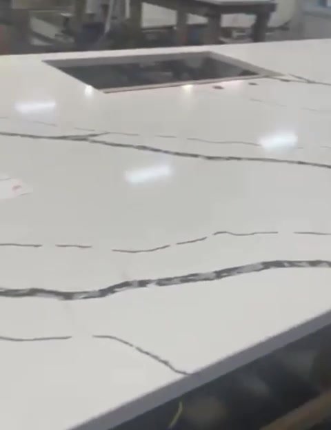 Polished white quartz countertop with dark veining and a sink cutout, finished in the shop